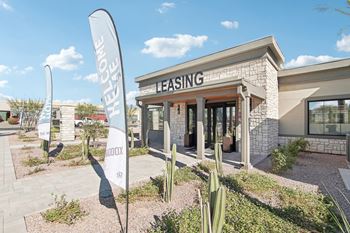 a leasing office with cactus signs in front of it at The Maddox Luxury Apartment Homes, Buckeye, AZ